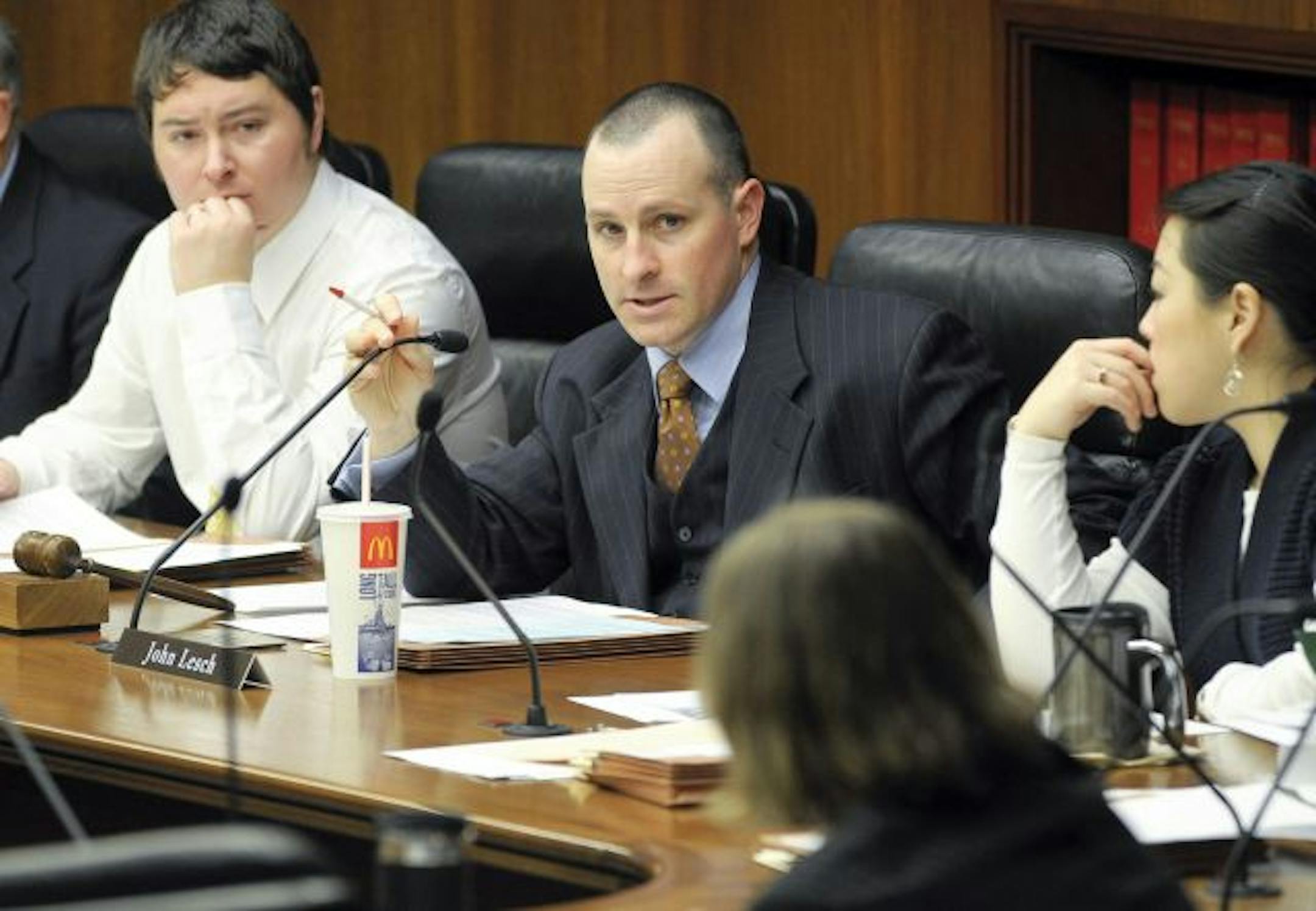 Rep. John Lesch, center, DFL-St. Paul, talked with a colleague on the House floor in March.