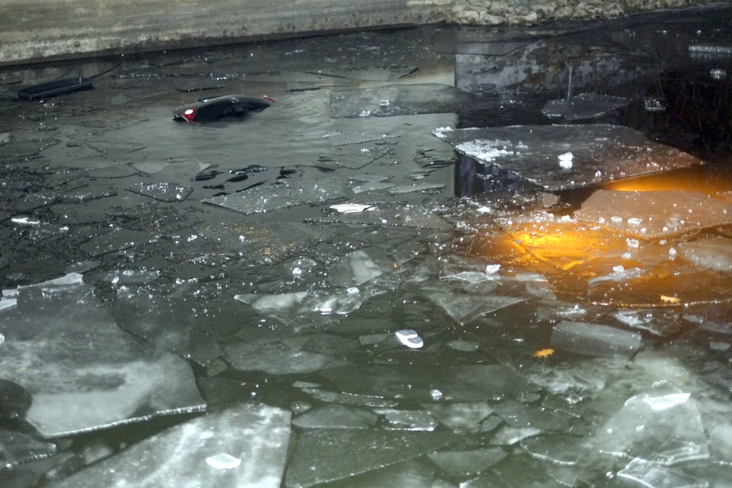 Lights from a submerged vehicle under a bridge across a Lake Minnetonka channel. The car went through the ice with 4 people inside. One of those four, Tabitha Markle, died.