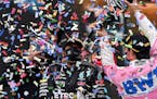 Second-place Racing Point driver Sergio Perez of Mexico, right, poured champagne on winner Mercedes driver Lewis Hamilton of Britain on the podium of 