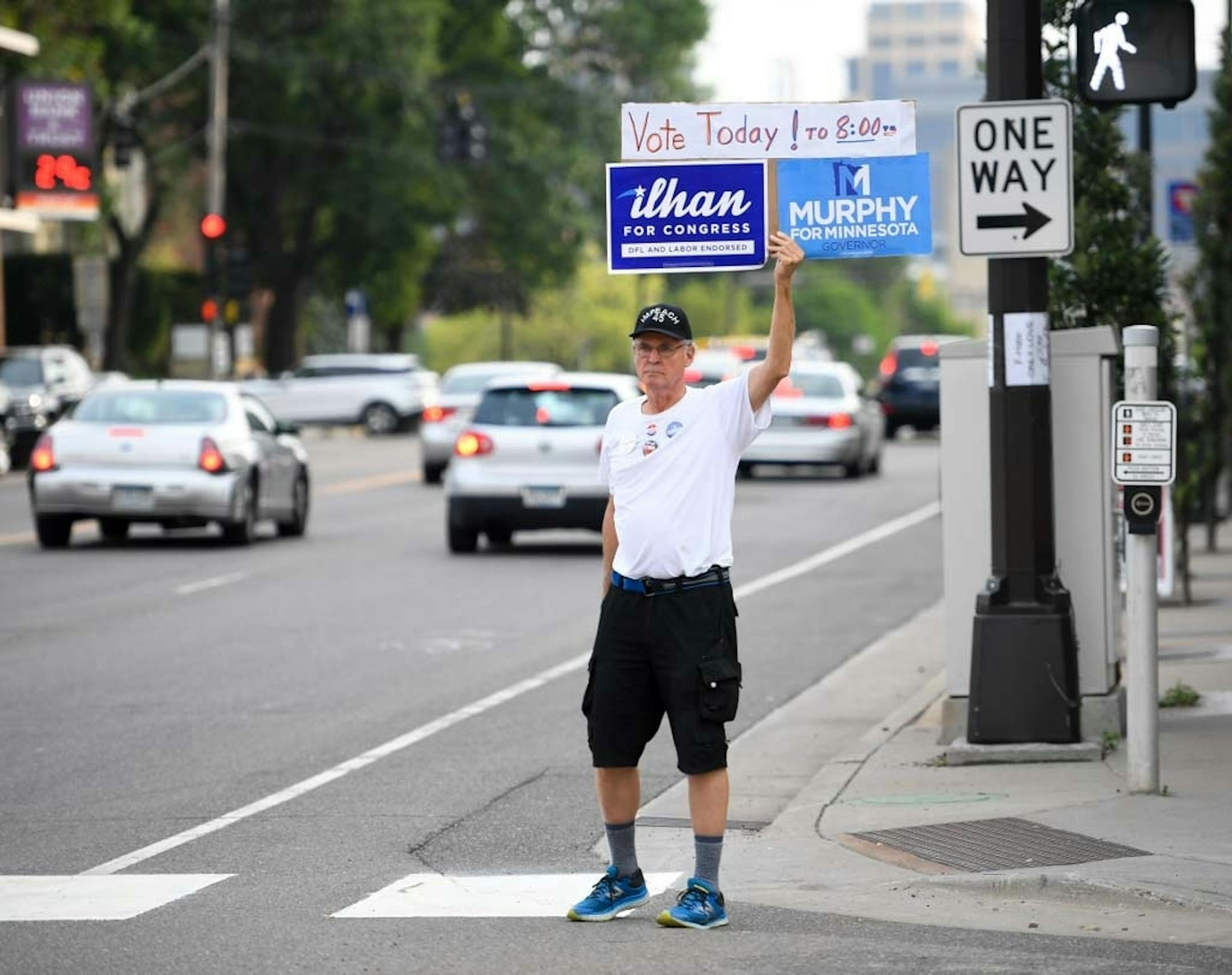 Larry Dunham, of northeast Minneapolis, sought the attention of motorists at Central and University to show support for gubernatorial candidate Erin Murphy and CD-5 congressional candidate Ilhan Omar during rush hour Tuesday night. On Murphy, Dunham says "she's the next Paul Wellstone in intelligence, passion and willingness to fight."