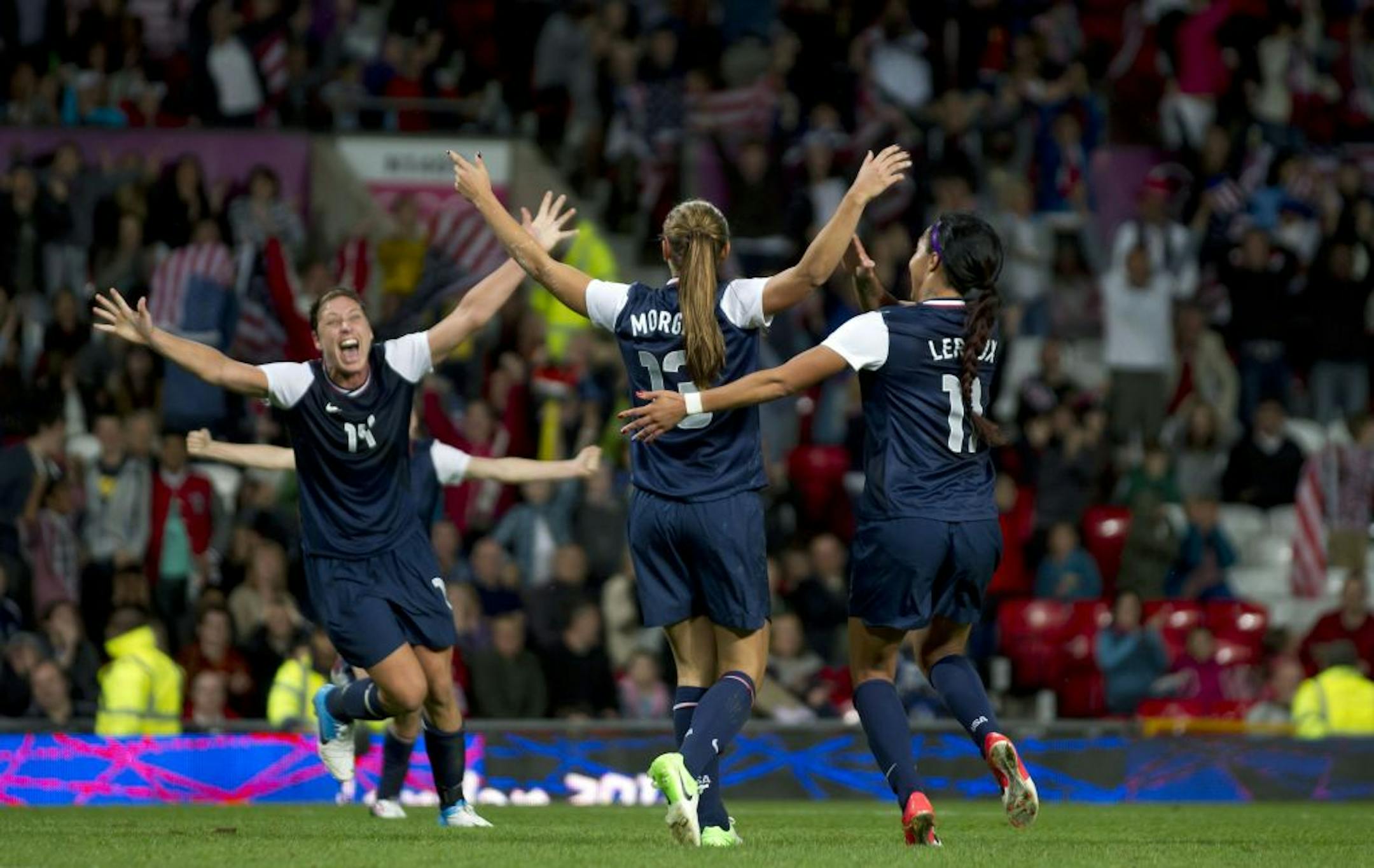 United States' Alex Morgan, center, celebrates with teammates including Abby Wambach, left, and Sydney Leroux after the winning goal was scored past Canada's goalkeeper Erin Mcleod during their semifinal women's soccer match at the 2012 London Summer Olympics, Monday, Aug. 6, 2012, at Old Trafford Stadium in Manchester, England.