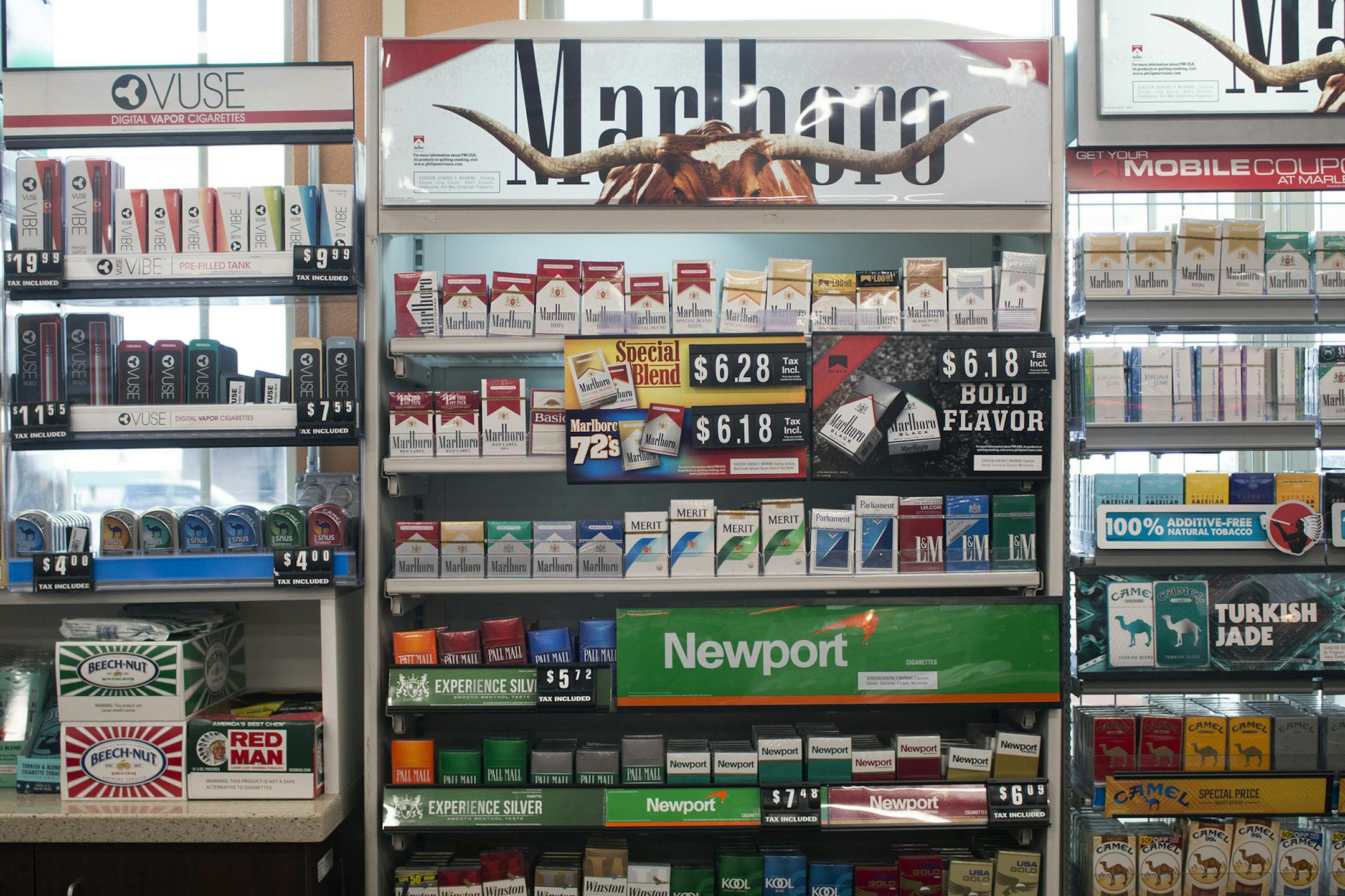 FILE - In this May 18, 2017 file photo, packs of cigarettes are offered for sale at a convenience store in Helena, Mont. A tobacco industry-funded group is asking the Montana Supreme Court to re-phrase a ballot initiative that would raise tobacco taxes to pay for the state's Medicaid expansion and other health programs. The lawsuit filed Monday. Aug. 6, 2018 by Montanans Against Higher Taxes says the ballot statement's wording is incorrect and will cause voter confusion. (AP Photo/Bobby Caina Ca