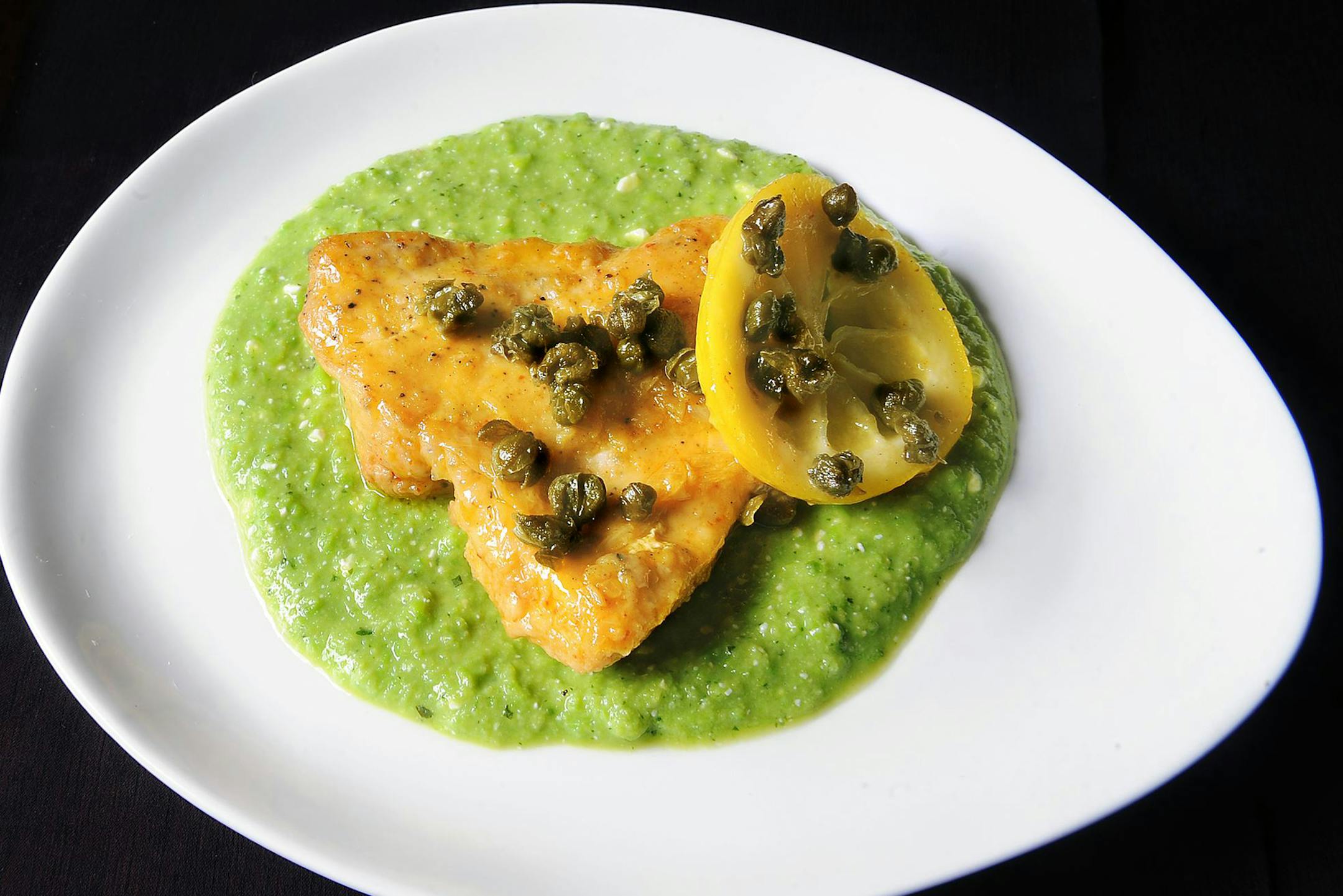 Sauteed lemon chicken and fried capers from "Sara Mouton's Home Cooking 101" sits on sweet pea puree that has a slight kick. (Nate Guidry/Pittsburgh Post-Gazette/TNS)