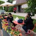 Shanay Ponder, left, answers a call while she sits with her mother, Inez Howard, at the new parklet seating outside of Twin Cities Coffee and Deli on 