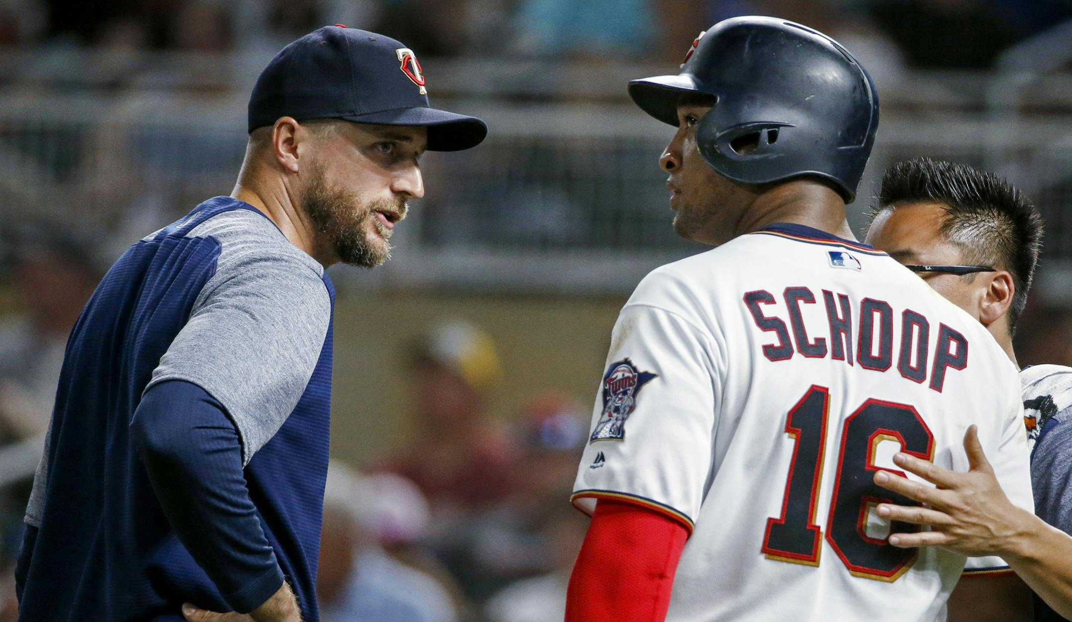 Minnesota Twins manager Rocco Baldelli talks with Jonathan Schoop about an injury during his at-bat against the New York Mets in the ninth inning of a baseball game Tuesday, July 16, 2019, in Minneapolis. The Mets won 3-2. (AP Photo/Bruce Kluckhohn)
