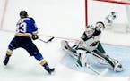 St. Louis Blues' Dmitrij Jaskin, of Russia, scores past Minnesota Wild goalie Devan Dubnyk, right, during the first period of an NHL hockey game Satur