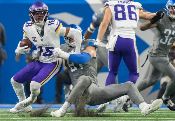 Minnesota Vikings wide receiver Justin Jefferson (18) was tackled in the back field for a 9 yard loss by Detroit Lions defensive end Levi Onwuzurike (