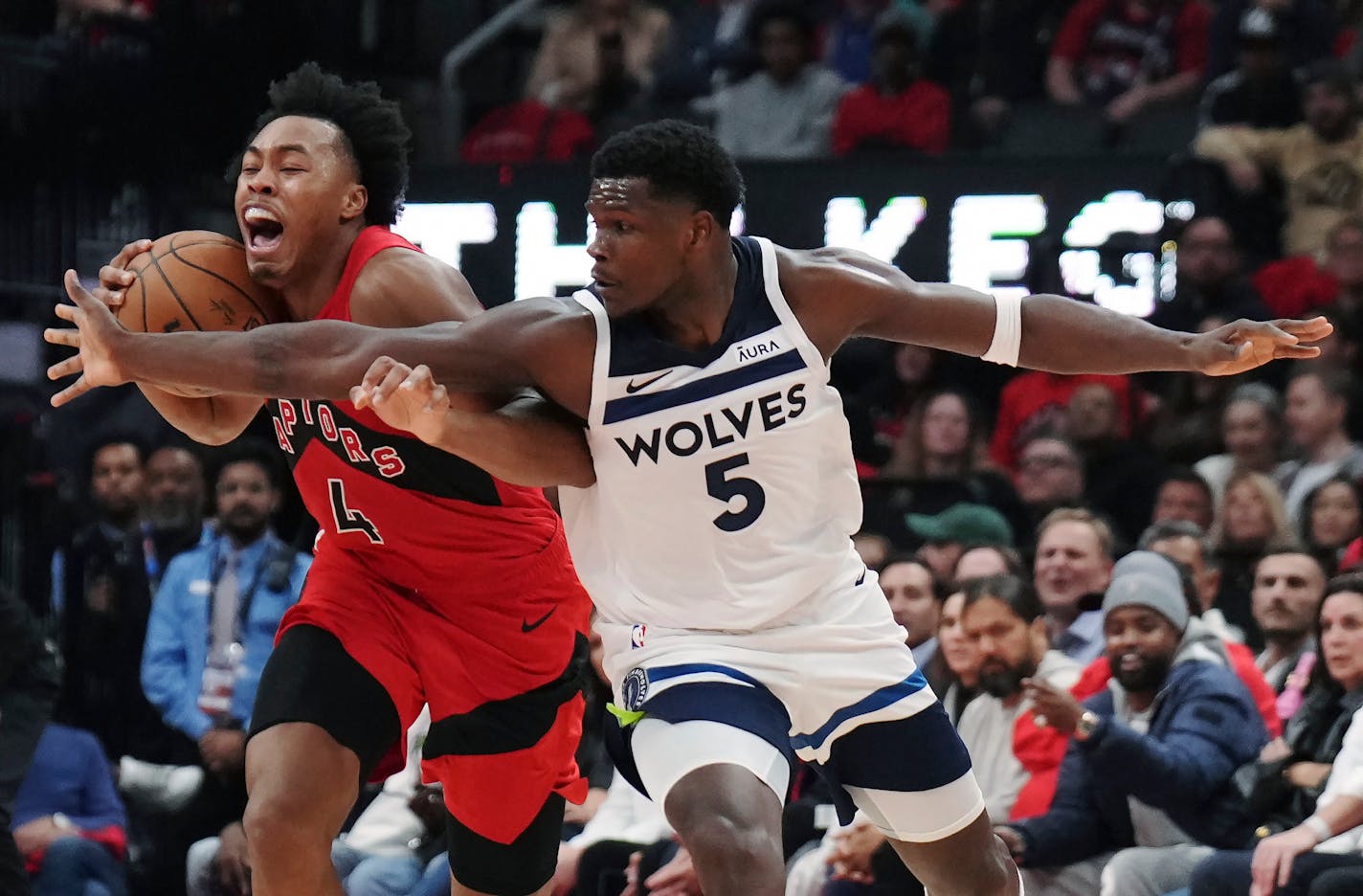 Toronto Raptors' Scottie Barnes (4) tries to keep the ball from Minnesota Timberwolves' Anthony Edwards (5) during the first half of an NBA basketball game Wednesday, Oct. 25, 2023, in Toronto. (Nathan Denette/The Canadian Press via AP)