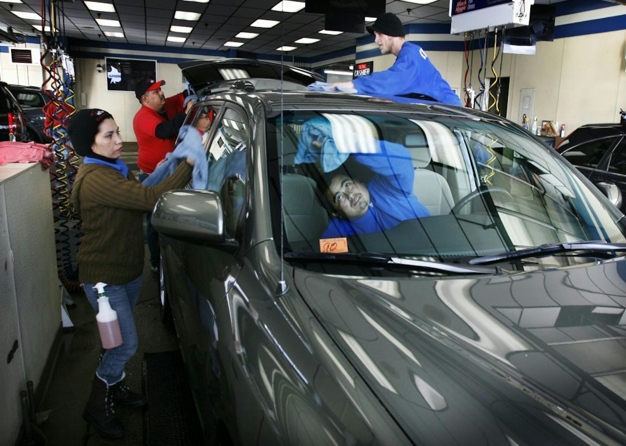 DAVID JOLES * djoles@startribune.com St. Paul, MN - Jan. 12, 2010- Sub zero temps have given way to a thaw the past few days and for some that means the time to get salt and grime washed from their vehicles. At the Downtowner Car Wash in St. Paul, business was brisk Tuesday afternoon. Here, Rosy Flores, left, and fellow workers wipe dry a freshly washed car.