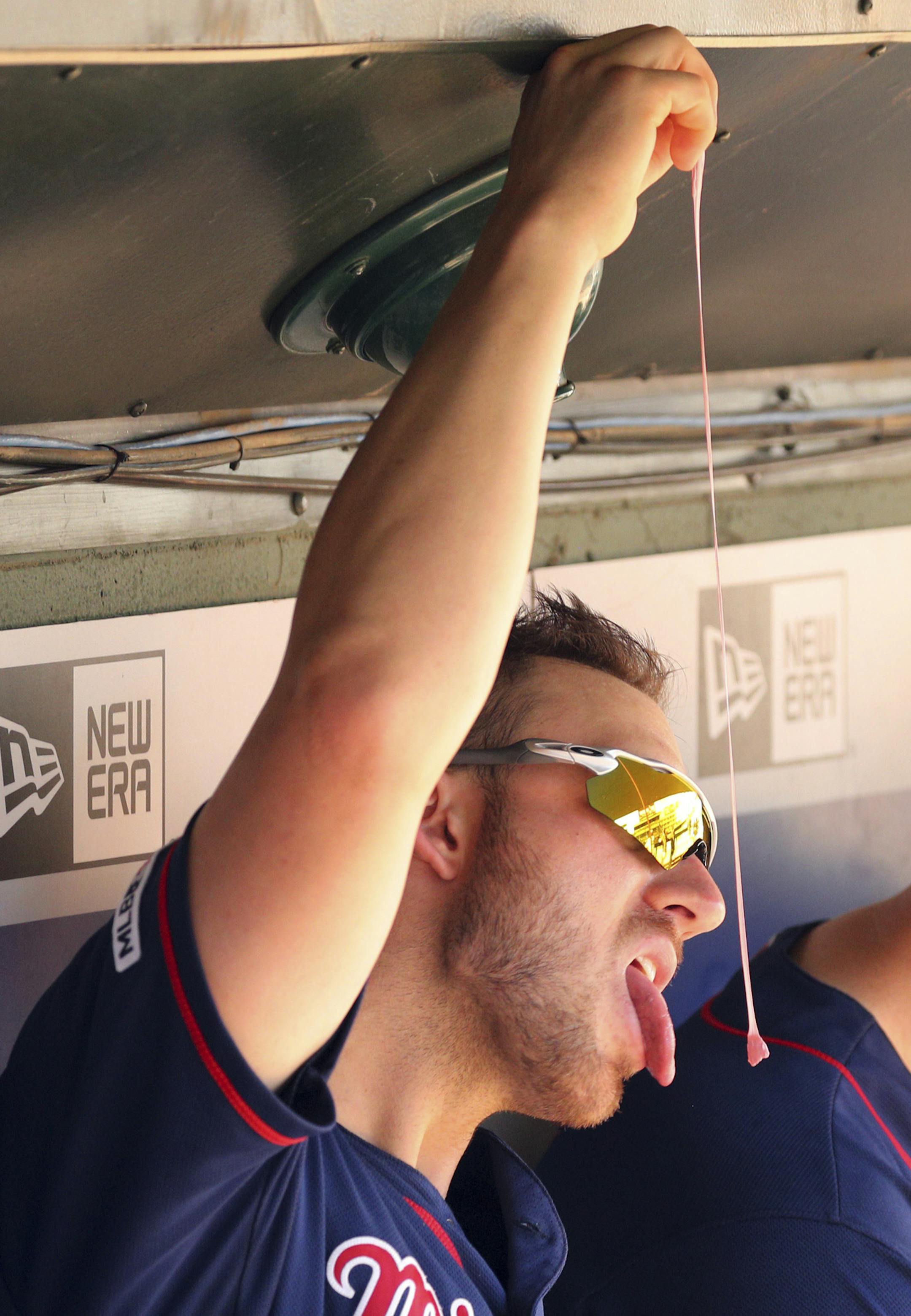 Minnesota Twins catcher Mitch Garver (18) plays with his gum in the dugout during during a baseball game against the Texas Rangers Sunday, Aug. 18, 2019, in Arlington, Texas. (AP Photo/Richard W. Rodriguez)