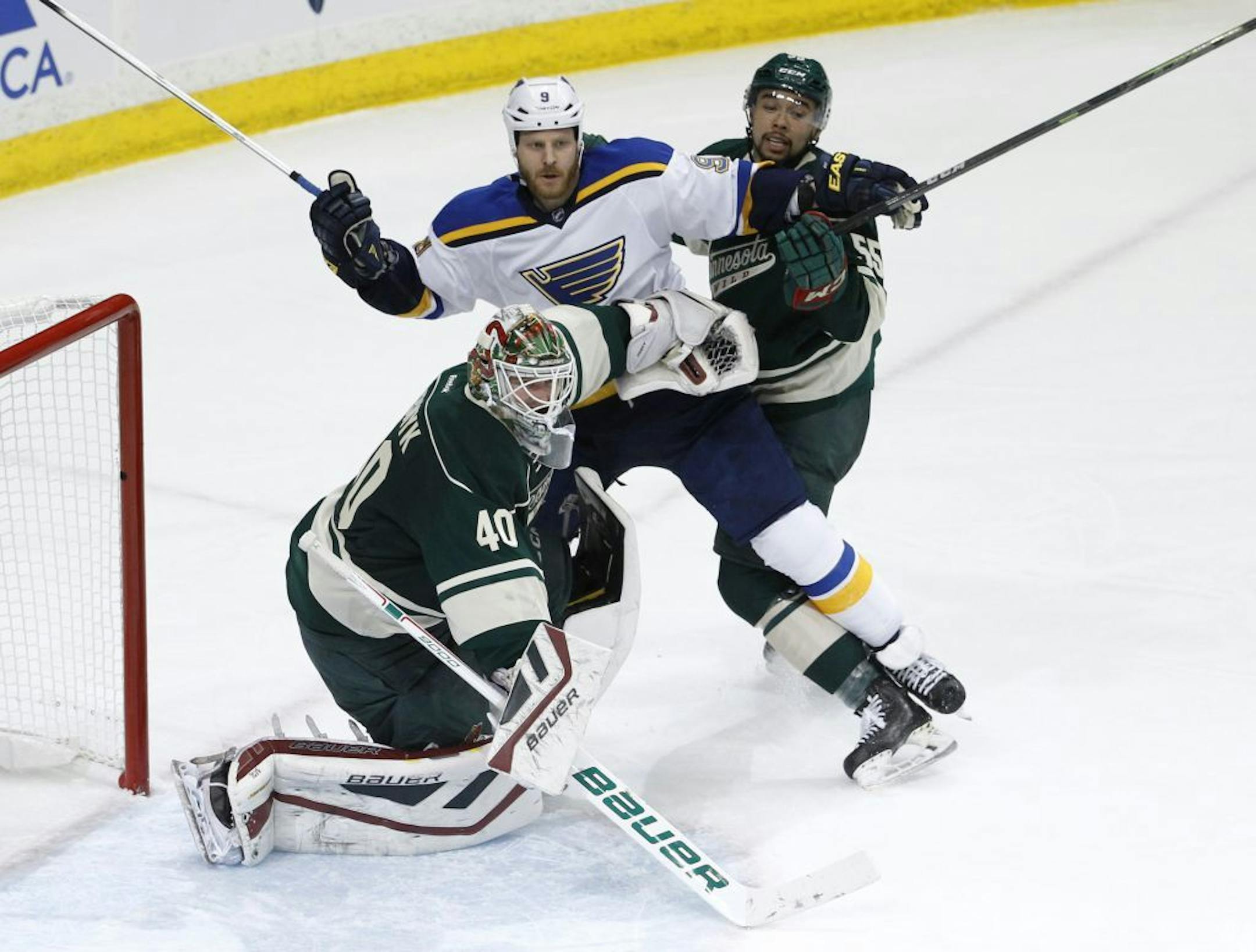 Minnesota Wild goalie Devan Dubnyk (40) clears St. Louis Blues center Steve Ott (9) and Wild defenseman Matt Dumba, right, away from the net during the third period of Game 3 of an NHL hockey first-round playoff series game in St. Paul, Minn., Monday, April 20, 2015. The Wild won 3-0.