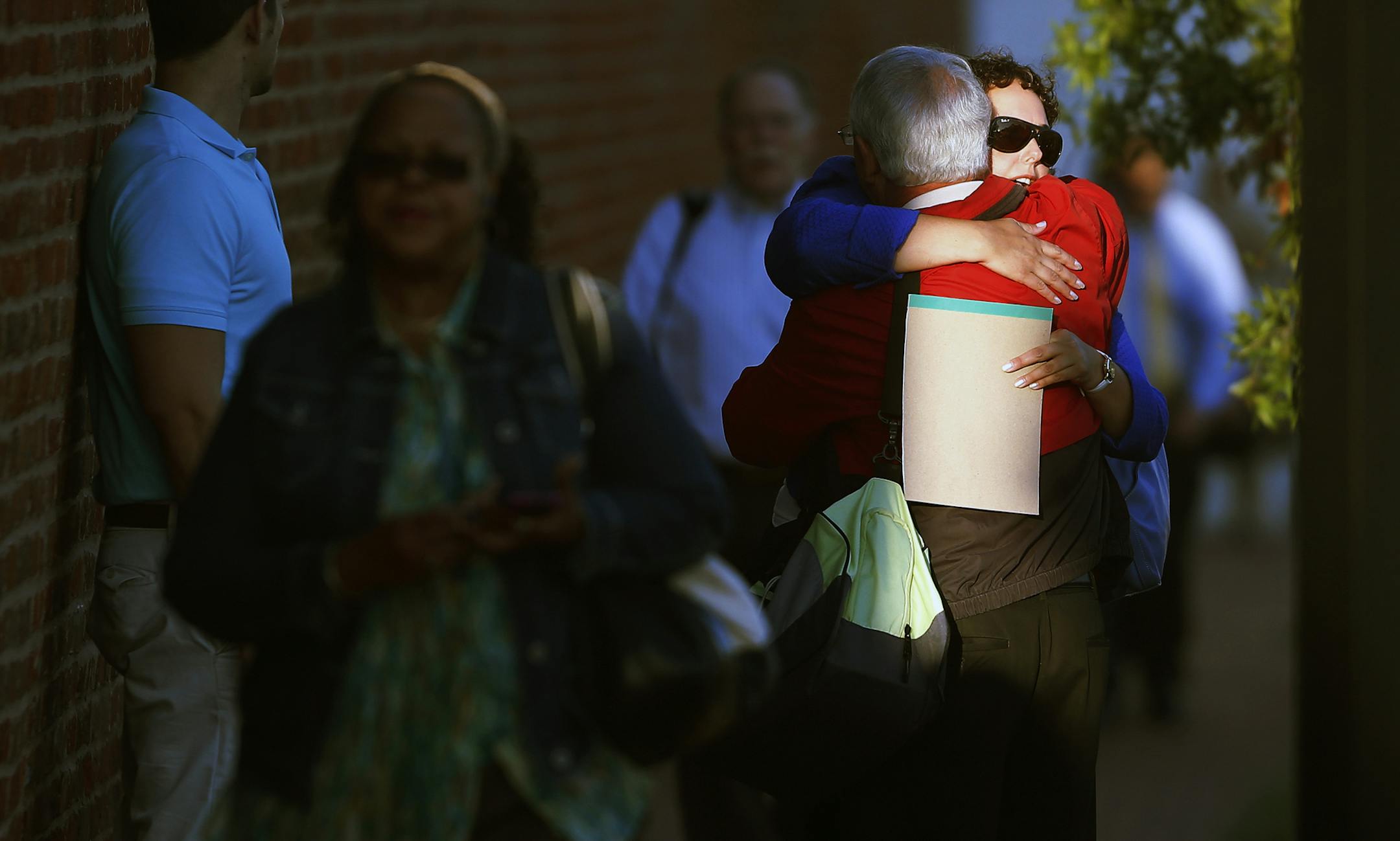 Cleared to return: A woman on Thursday embraced a man before entering the Washington Navy Yard as employees return to work three days after the site was the scene of a mass shooting. Worker Bob Flynn said about returning, “I get to hug people … and we get to talk about it and I think it’s going to be helpful.”