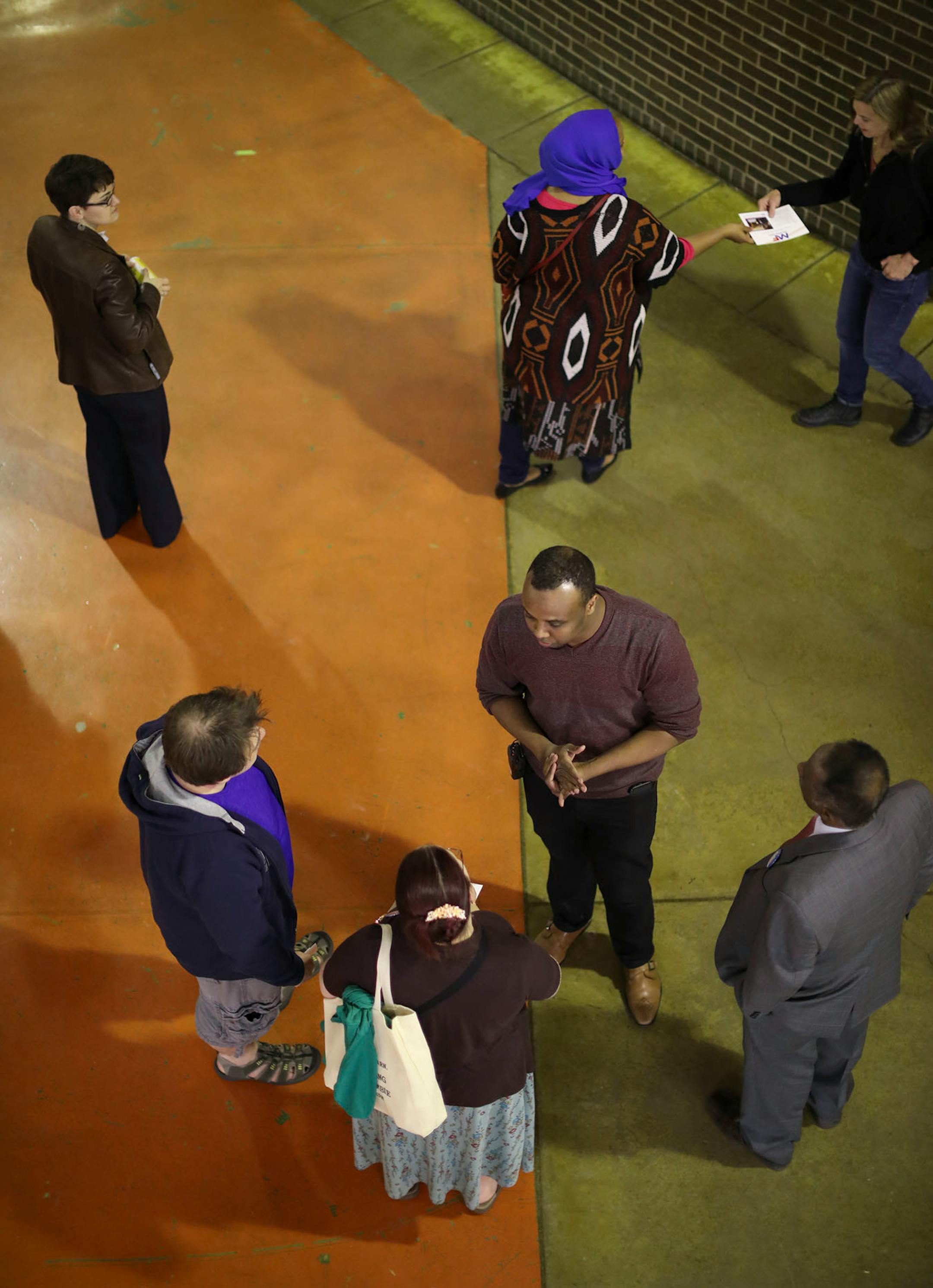 City council candidate Mhamed Farah, center below, talked to caucus attendees as they arrived in the cafeteria at South High School.