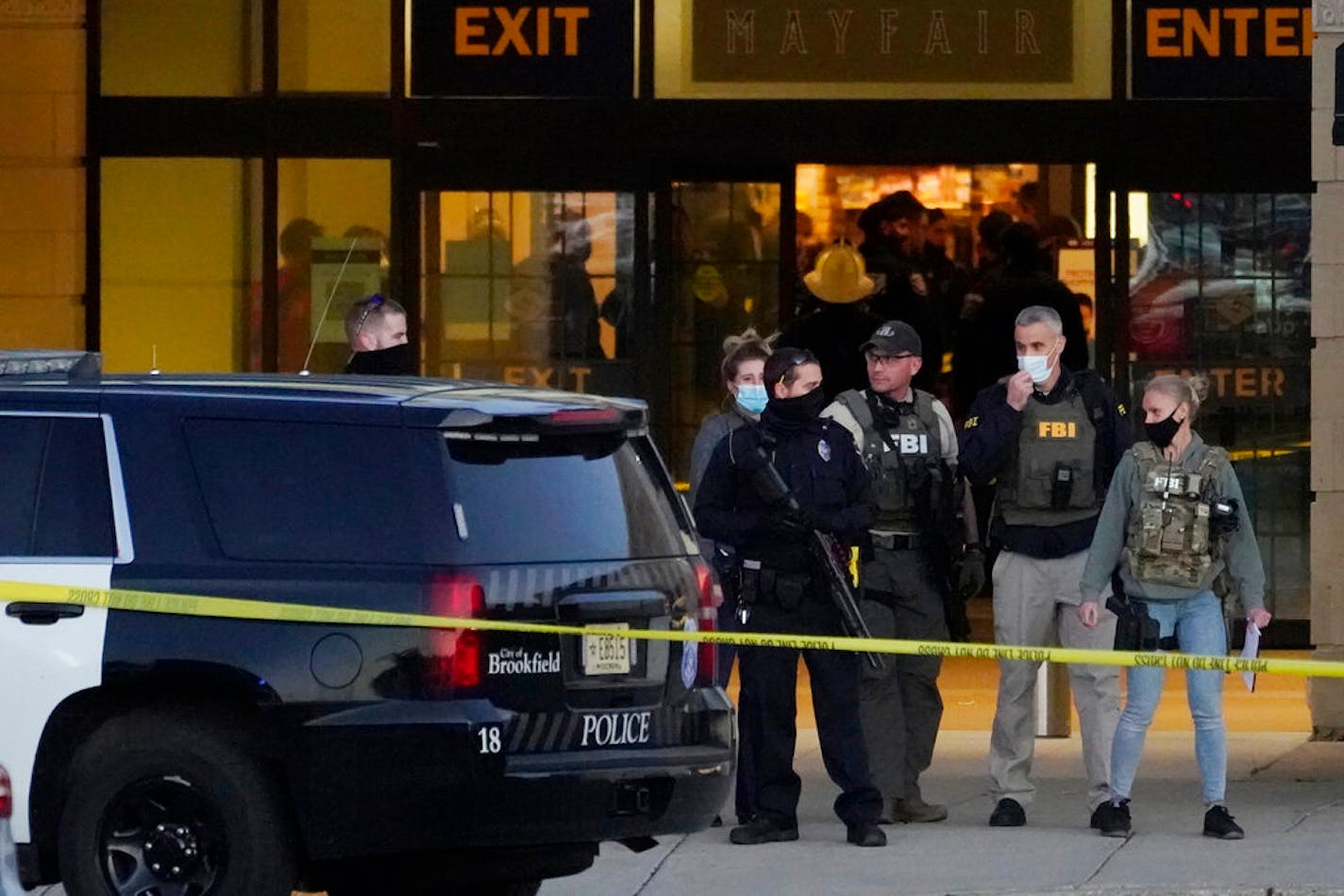 FBI officials and police stand outside the Mayfair Mall after a shooting, Friday, Nov. 20, 2020, in Wauwatosa, Wis.