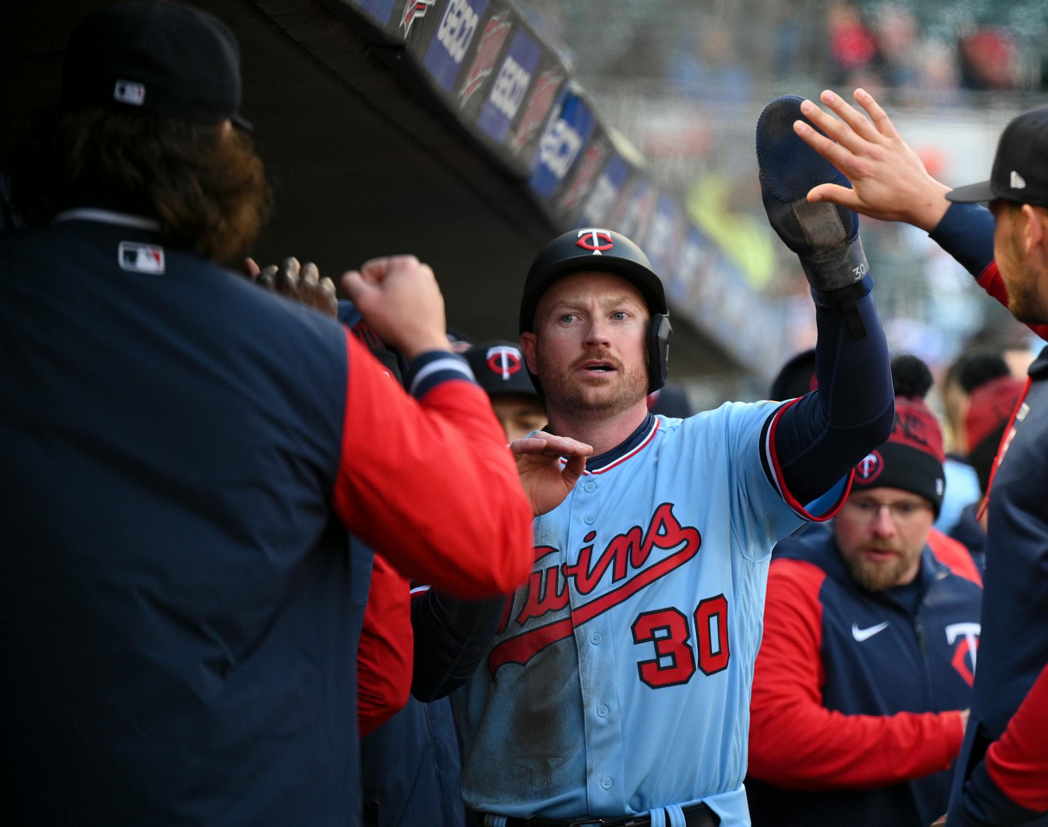 Minnesota Twins left fielder Kyle Garlick (30) high fives teammates after scoring a run off an RBI double hit by Minnesota Twins right fielder Max Kepler (26) in the bottom of the second inning.