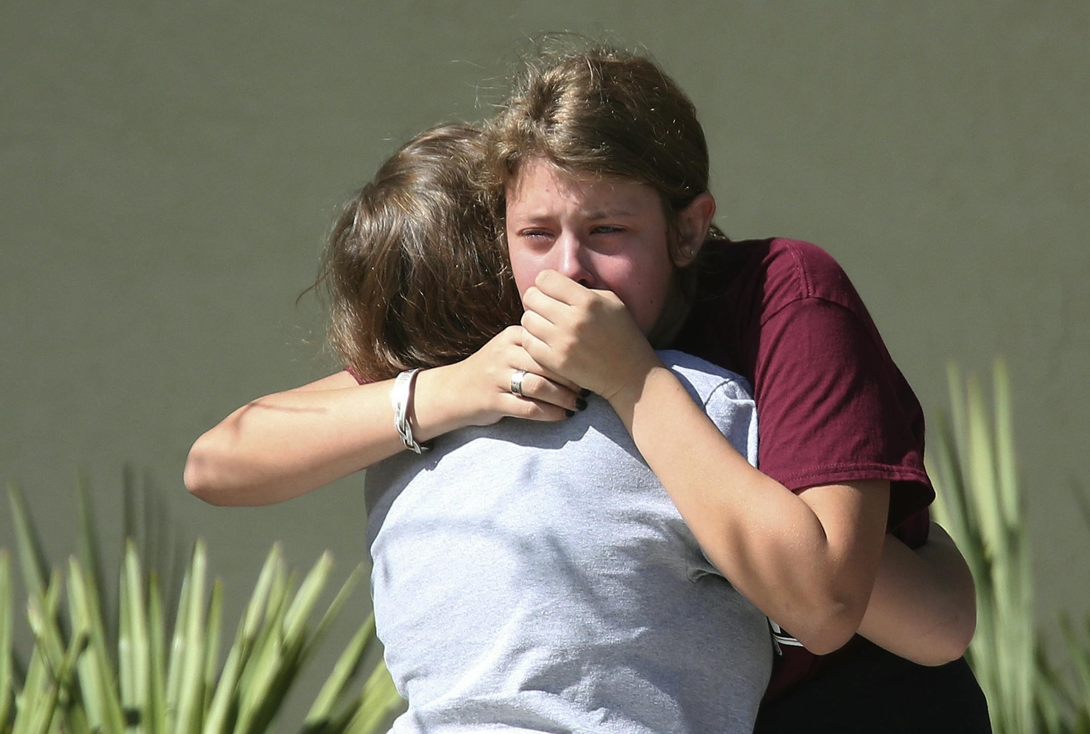 Students grieve outside Pines Trail Center where counselors are present, after Wednesday's mass shooting at Marjory Stoneman Douglas High School in Parkland, Fla., Thursday, Feb. 15, 2018. Nikolas Cruz was charged with 17 counts of premeditated murder Thursday morning.