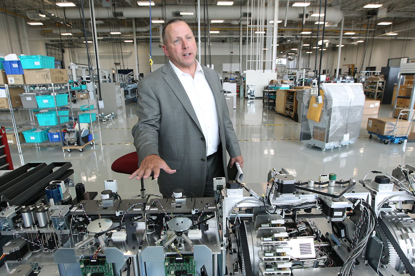 Todd Wilkinson, president and chief executive of Entrust Datacard, shows one of the company's larger credit card machines at Datacard's Shakopee plant. (ELIZABETH FLORES/STAR TRIBUNE)