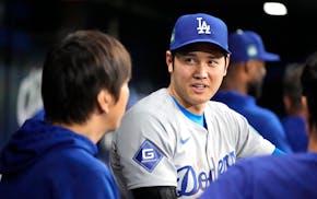 Shohei Ohtani, right, talks with interpreter Ippei Mizuhara during a game against the Padres at the Gocheok Sky Dome in Seoul, South Korea, on March 2