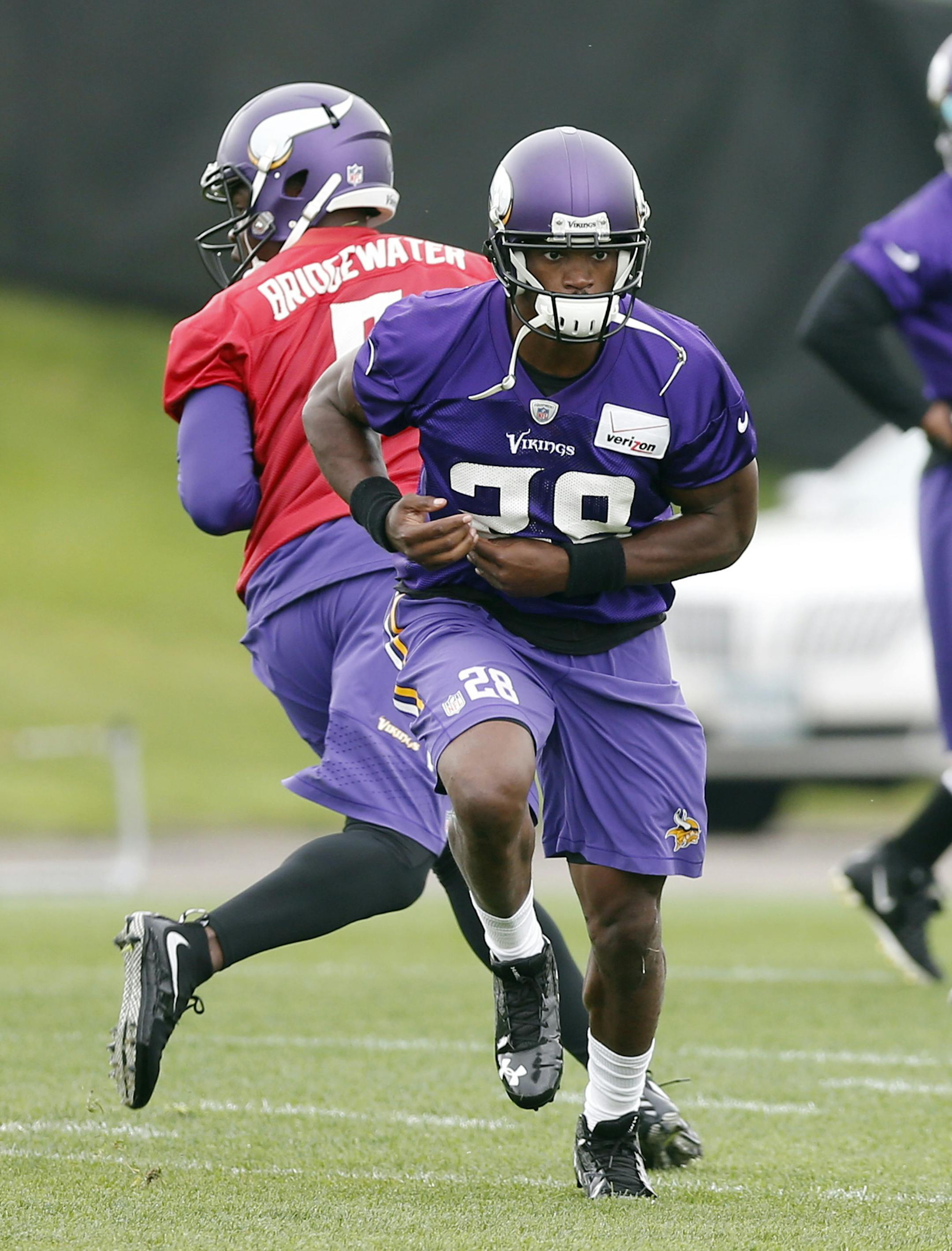 Minnesota Vikings quarterback Teddy Bridgewater, left, fakes a handoff to running back Adrian Peterson during an NFL football team practice, Thursday, June 4, 2015, in Eden Prairie, Minn. (AP Photo/Jim Mone) ORG XMIT: MIN2015071420373786