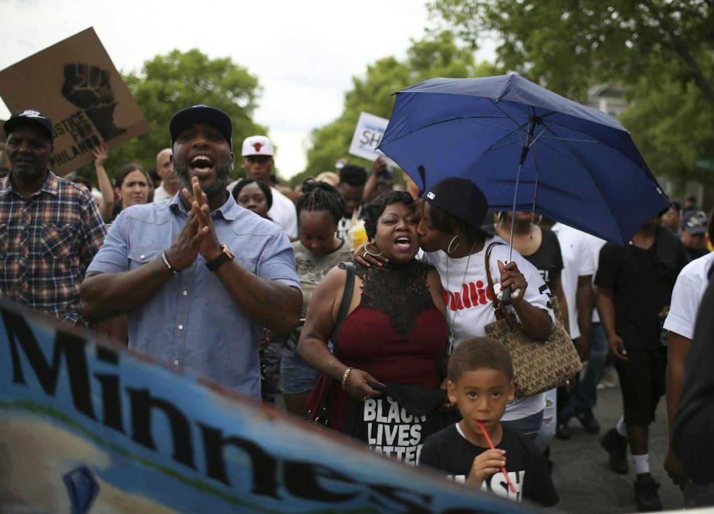 Valerie Castile, the mother of Philando Castile, was kissed by her son's girlfriend, Diamond Reynolds, as they led marchers from the J.J. Hill Montessori Magnet School to the governor's residence in St. Paul on Thursday night.