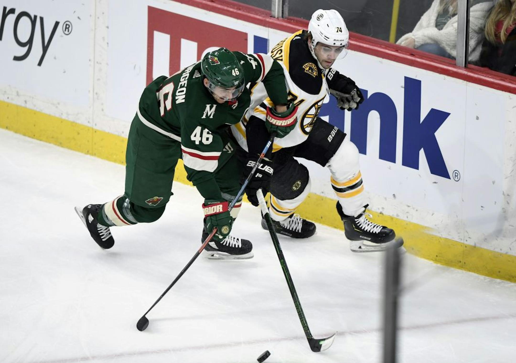 Minnesota Wild's Jared Spurgeon (46) and Boston Bruins' Jake DeBrusk (74) go after the puck during the first period of an NHL hockey game Saturday, Feb. 1, 2020, in St. Paul, Minn.
