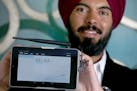 Deepinder Singh held up a computer software program that controls temperature at his Burnsville, MN office, Thursday, February 26, 2015. Singh, a comp