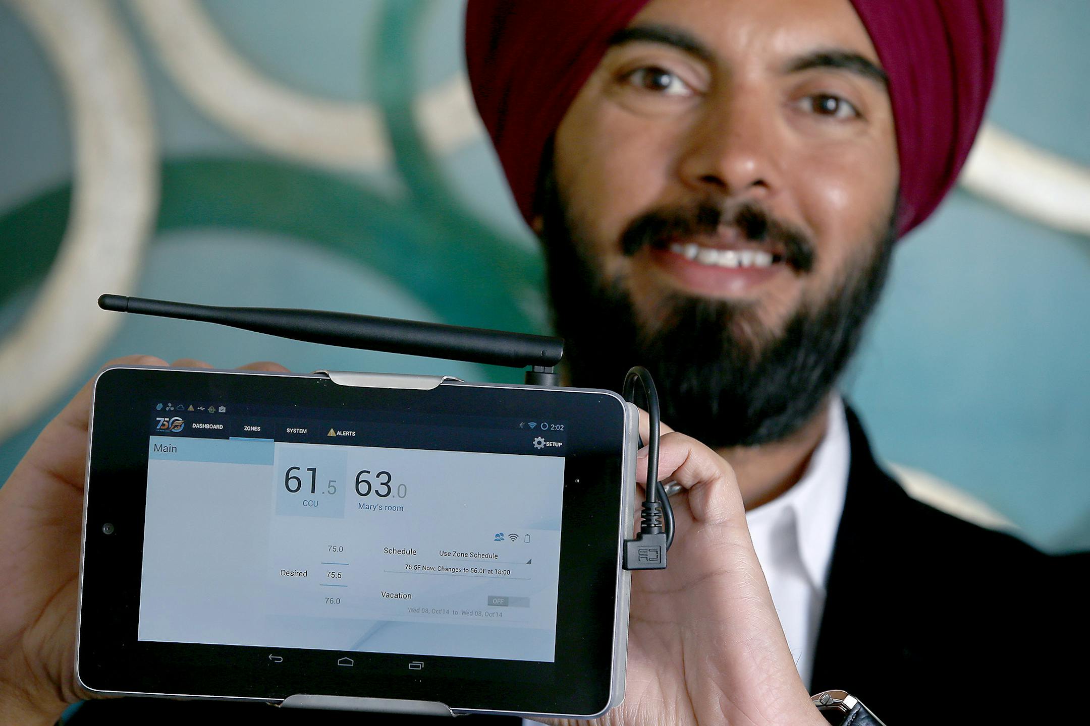 Deepinder Singh held up a computer software program that controls temperature at his Burnsville, MN office, Thursday, February 26, 2015. Singh, a computer scientist, quit his job in Detroit a f ew years ago to follow his physician-wife's career to Mankato, Minn. Their drafty house and a crying baby led him to start 75F, a software-driven company that controls room-by-room temperature and saves energy for small commercial buildings, the neglected part of the market. Singh, 40, and his 15-person c