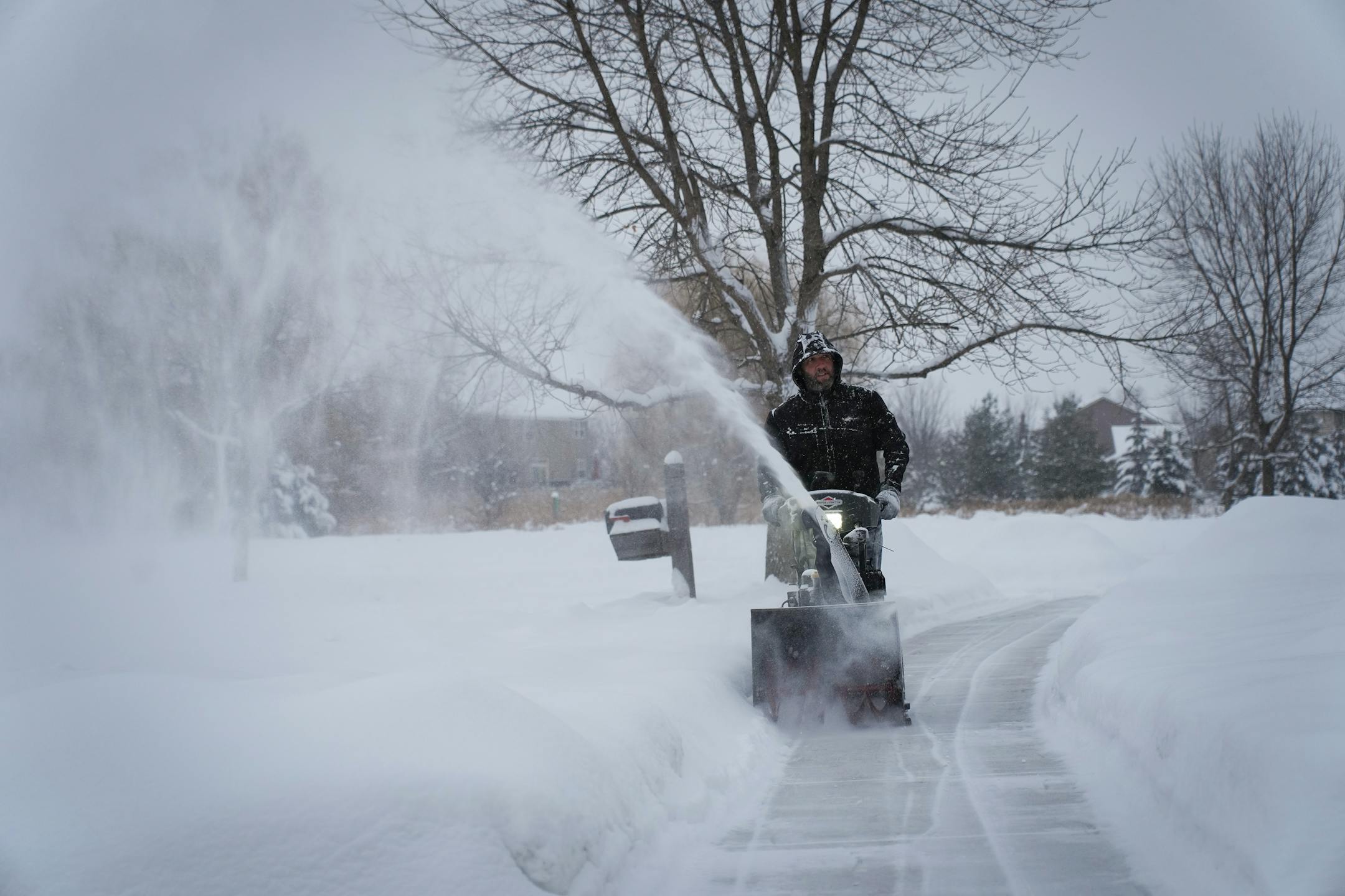 Even though plenty more snow is on the way, Jamie Thompson came home from work to begin blowing clear the driveway and sidewalk at his home in Maple Grove, Minn., on Wednesday, Dec. 21, 2022. "We just came back from Florida," Thompson said. "I love it. I love it so much I'm going to blow out my neighbors, too."