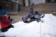 Friends Clayton and Brayden, both 6, play in a pile of snow in Apple Valley on Friday.