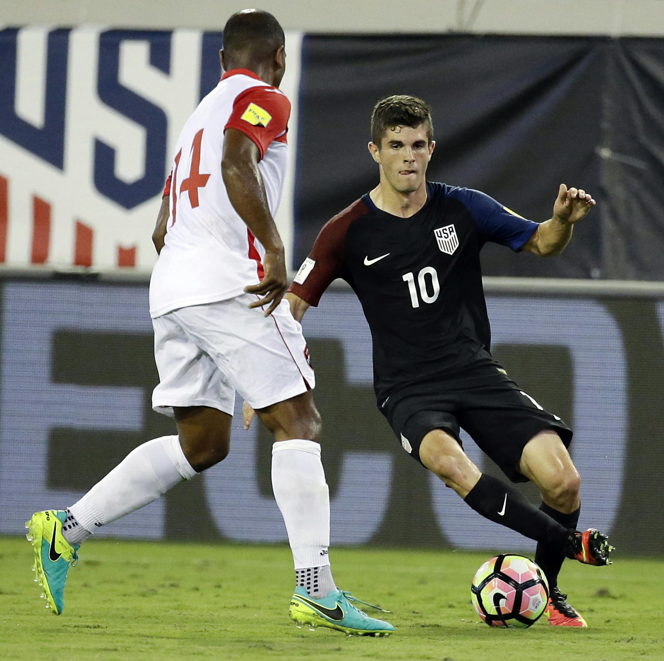 United States' Christian Pulisic (10) tries to moves the ball around Trinidad & Tobago's Andre Boucaud (14) during the first half of a CONCACAF World Cup qualifying soccer match, Tuesday, Sept. 6, 2016, in Jacksonville, Fla. (AP Photo/John Raoux)