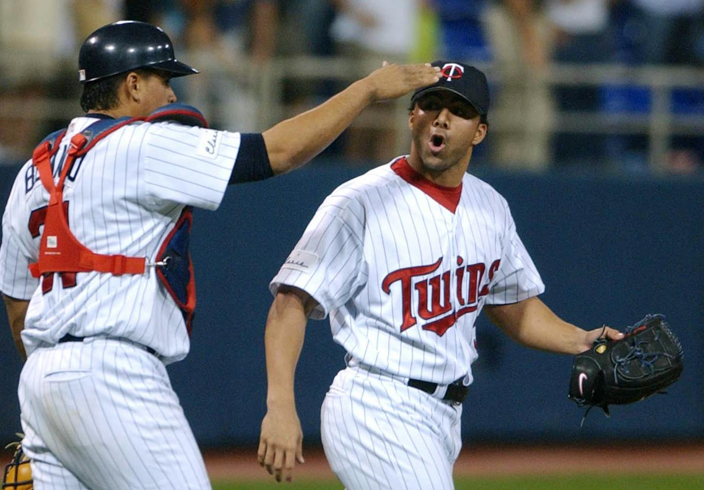 Minnesota Twins catcher Henry Blanco, left, gives a pat on the head to closing pitcher J.C. Romero after the final out of the game as the Twins beat the New York Yankees 8-2 Tuesday, Aug. 17, 2004 in Minneapolis. (AP Photo/Jim Mone)