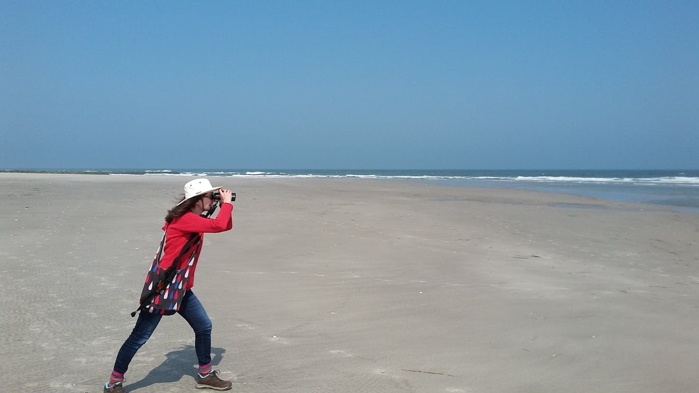 Julia Zarankin birding on a Canadian beach.