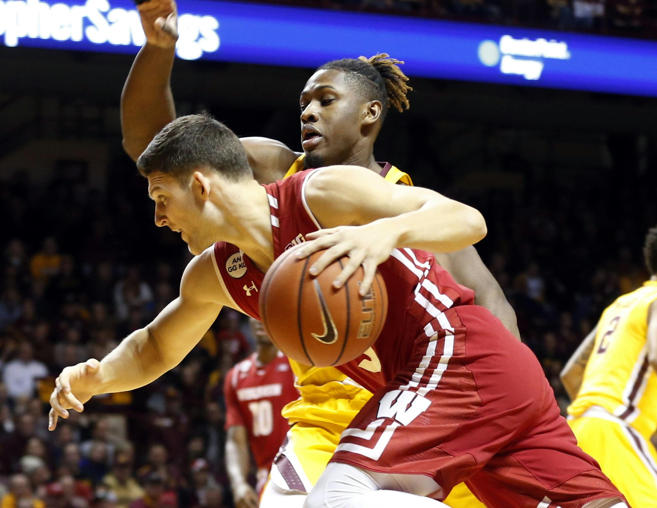Wisconsin's Zak Showalter, left, drives past Minnesota's Akeem Springs during the first half of an NCAA college basketball game Saturday, Jan. 21, 2017, in Minneapolis. (AP Photo/Jim Mone)