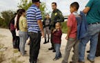 Ely Fernandez is questioned by border patrol agent Robert Rodriguez after being detained for crossing the border illegally with his son 5-year-old Bry