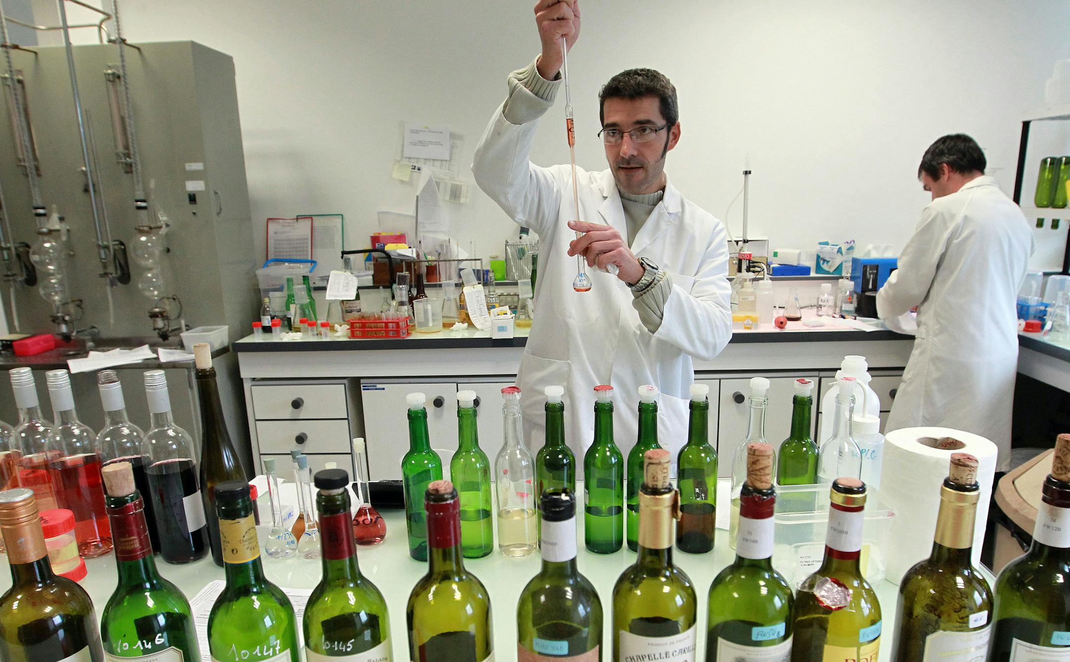 In this photo dated Tuesday, Nov. 12, 2013, an unidentified lab worker tests wine for authenticity in a lab run by the French Finance ministry in Bordeaux, southwestern France. Counterfeiting has dogged wine as long as it has been produced, but it is getting more sophisticated and more ambitious, particularly as bottle prices rise due to huge demand in new markets, mainly in Asia. (AP Photo/Bob Edme)