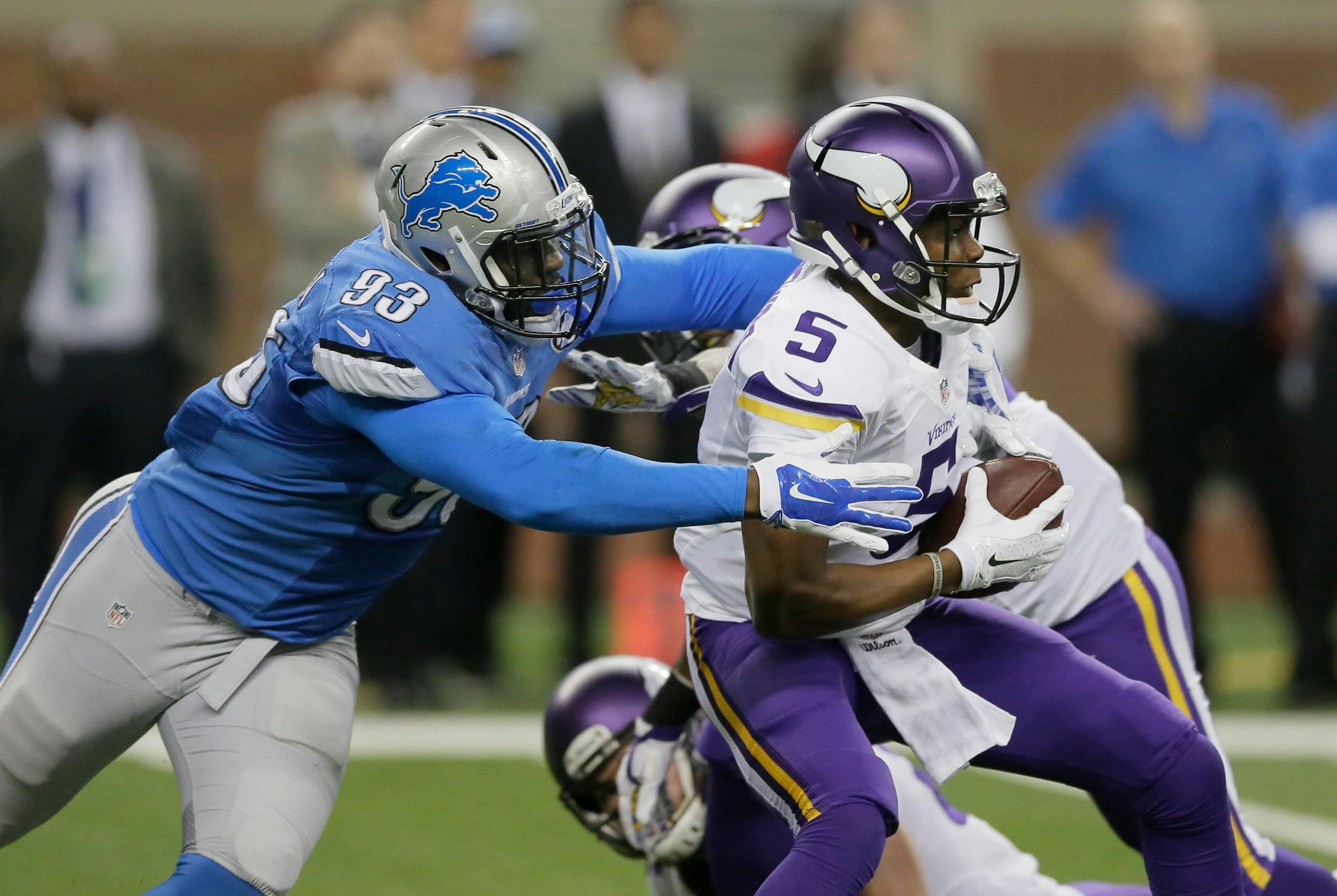 Minnesota Vikings quarterback Teddy Bridgewater (5) pulls away from Detroit Lions defensive end George Johnson (93) during the first half of an NFL football game in Detroit, Sunday, Dec. 14, 2014. (AP Photo/Duane Burleson)