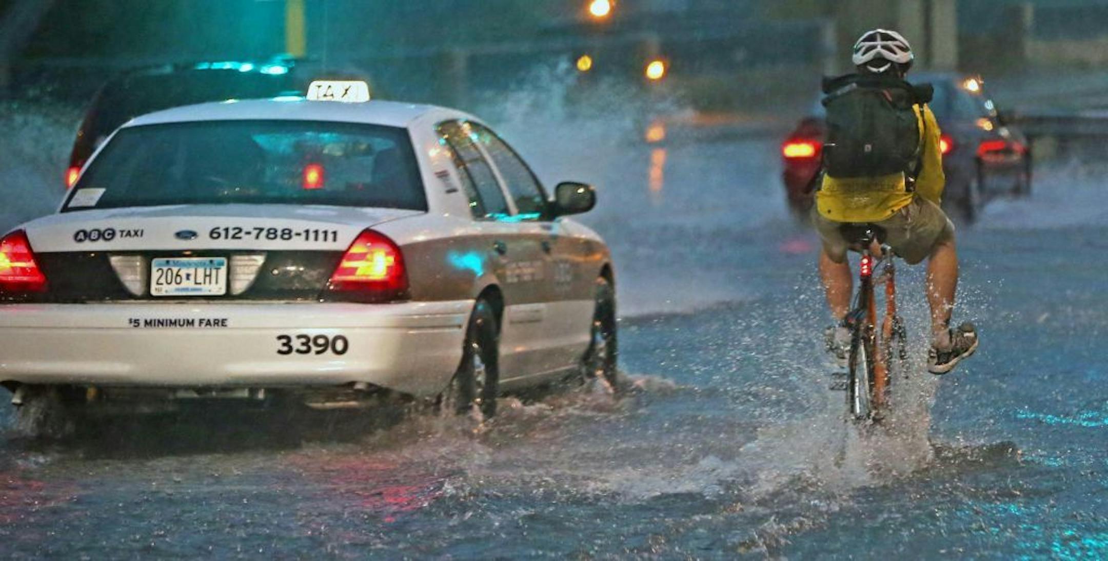 Motorists and bikers drove through deep water as they try to cross the Hennepin Ave. bridge near the main Post Office, Friday, June 21, 2013 in Minneapolis. Another round of heavy rain and high winds swept into the Twin Cities Friday night, less than 24 hours after damaging winds and heavy rain uprooted trees and knocked out power to more than 157,000 Xcel Energy customers. (AP Photo/The Star Tribune, Bruce Bisping) MANDATORY CREDIT; ST. PAUL PIONEER PRESS OUT; MAGS OUT; TWIN CITIES TV OUT ORG X