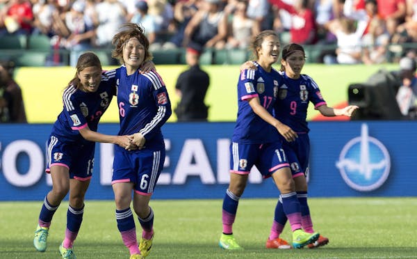 Japan's Rumi Utsugi (13), Mizuho Sakaguchi (6), Yuki Ogimi (17) and Nahomi Kawasumi (9) celebrate a 2-1 win over England in a semifinal in the FIFA Wo