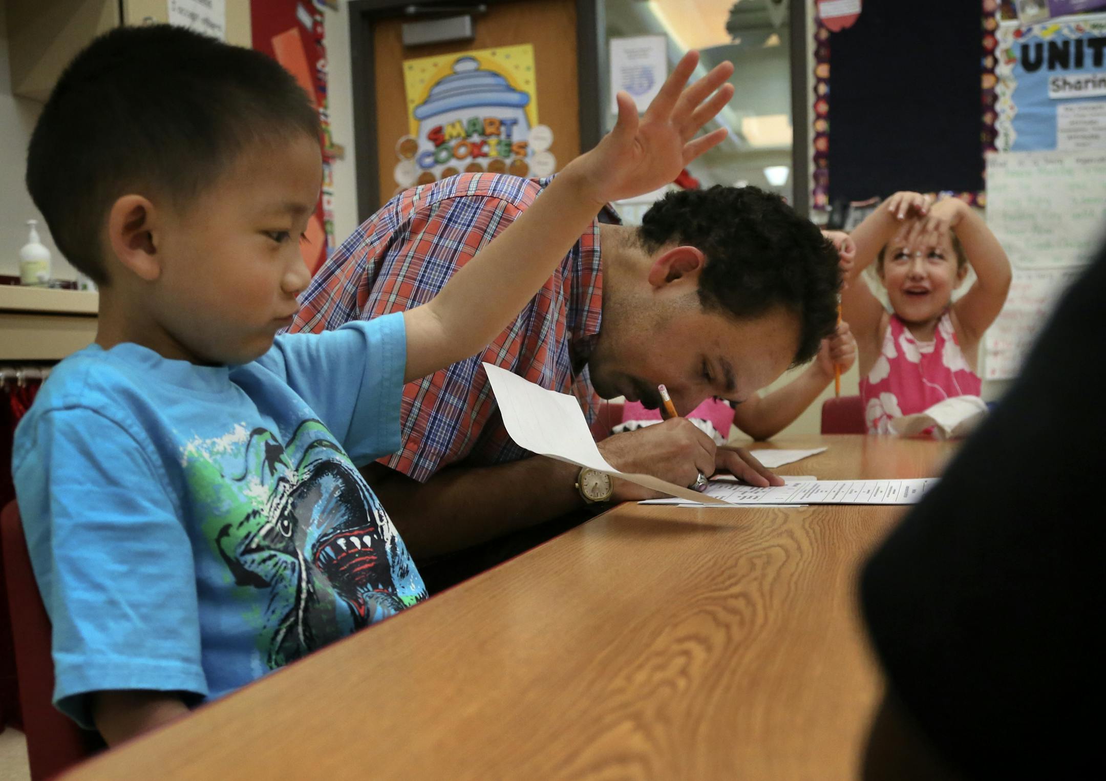 Jordan Richardson attends to paperwork related to verbal exercises with pre-K students Thursday, June 4, 2014, at Earle Brown Elementary School in Brooklyn Center, MN. Seated next to Richardson is Royce Angeles, left, and Kennedy Perkins. Richardson is a teaching aide at the school and is blind and has told the students but isn't sure they comprehend or care. "Does it matter?" he asks. "Does Being blind really have anything?"] (DAVIDJOLES/STARTRIBUNE) djoles@startribune.com Jordan Richardson, le