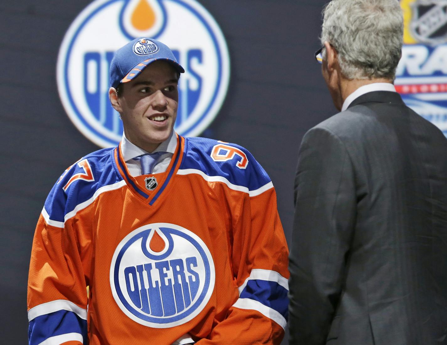 Connor McDavid, left, chats with Craig MacTavish after being chosen first overall by the Edmonton Oilers in the NHL hockey draft, Friday, June 26, 2015, in Sunrise, Fla. (AP Photo/Alan Diaz)