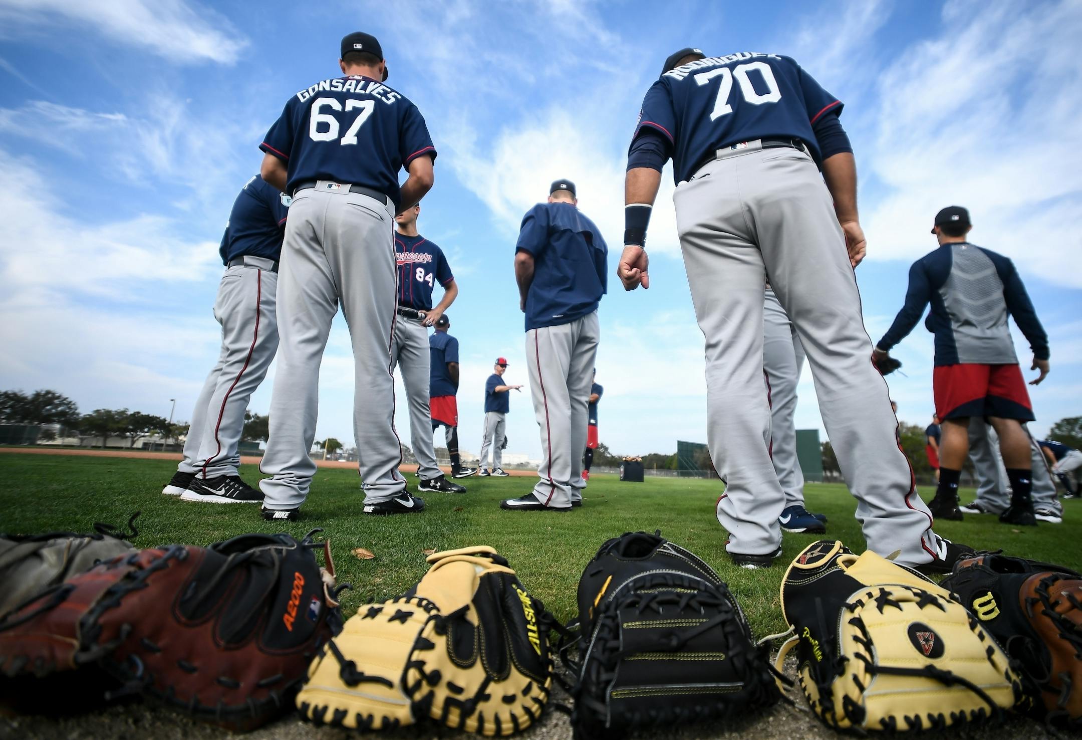 Twins catchers put their gloves down in a row before beginning their morning stretches Saturday.