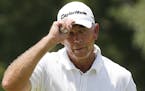 Tom Lehman tips his hat on the ninth green in the first round of play at the 2014 U.S. Senior Open golf tournament at Oak Tree National in Edmond, Okl