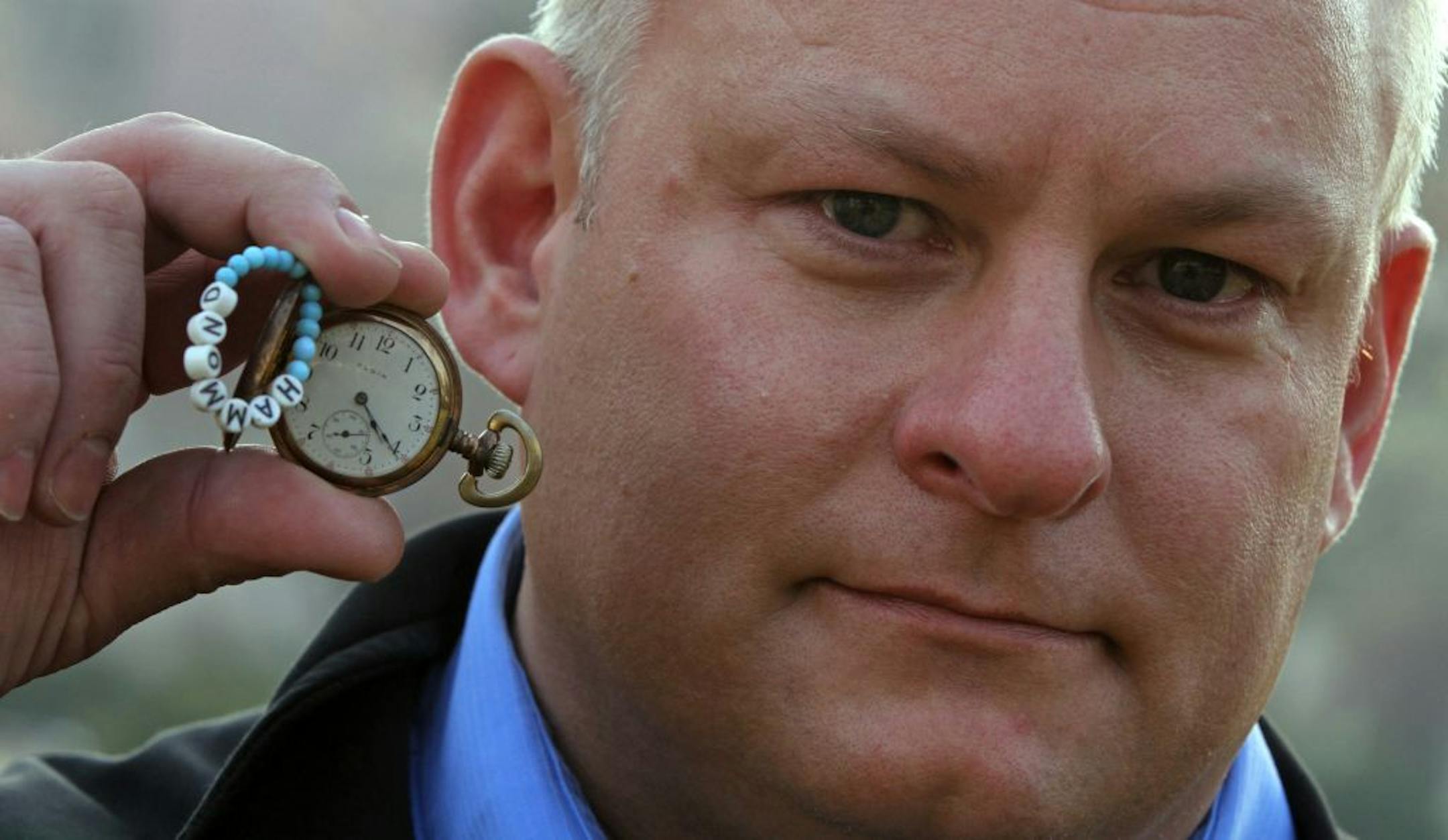 Mike Smith held his grandfather's gold pocket watch and a string and beads baby bracelet that were stolen and recovered by Ramsey police. Smith was photograped on 11/29/12. It was only after the police arrived that Mike Smith made his first through look throughout his Brooklyn Park home. Among the items stolen: a string-and-beads baby bracelet that Minneapolis Children's Hospital volunteers gave Smith's mother on the day he was born, and Smith's grandfather's 90-year-old gold pocket watch. Said