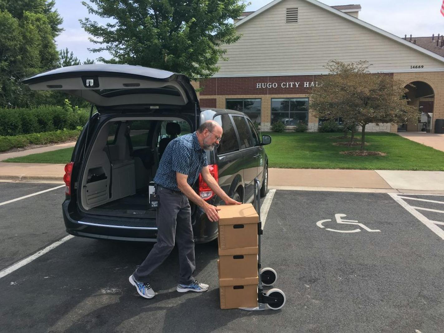 On Thursday, July 20, 2017, Charlie Rodgers, government records specialist at the Minnesota Historical Society, loads 12 boxes of records handed over by the Hugo City Clerk, outside City Hall.