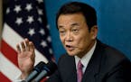 FILE - Then Prime Minister Taro Aso of Japan speaks with reporters during a news conference at the end of the financial summit in Washington, Nov. 15,
