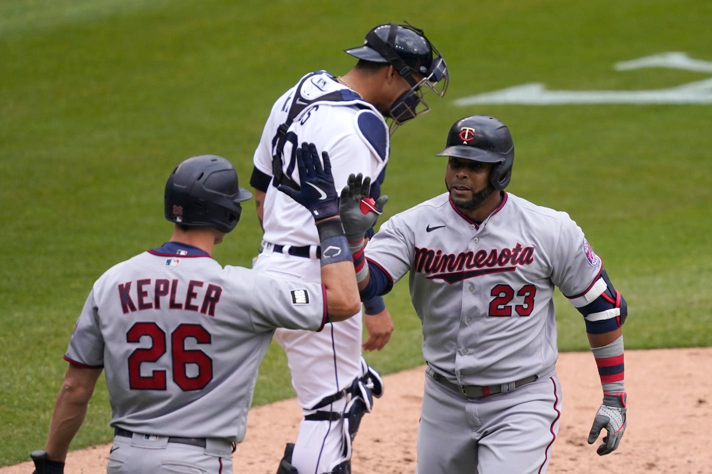 Minnesota Twins designated hitter Nelson Cruz, right, is greeted by teammate Max Kepler, left, after hitting a solo home run during the fifth inning of a baseball game, Monday, April 5, 2021, in Detroit. (AP Photo/Carlos Osorio)