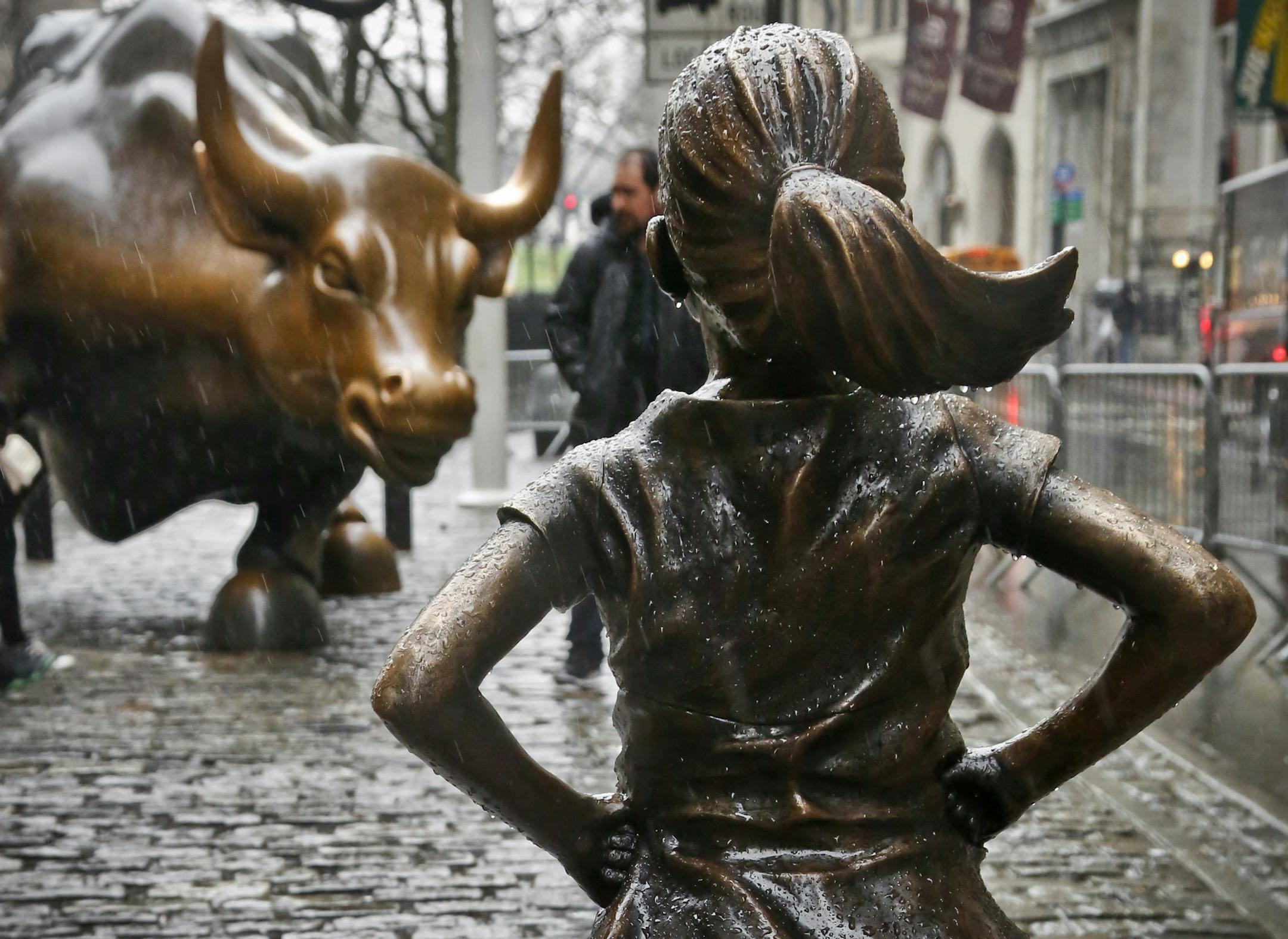 The "Fearless Girl" statue, created by Kristen Visbal, stands across from the "Charging Bull" statue, Monday, March 27, 2017, in New York. Mayor Bill de Blasio says the popular statue of a young girl will be allowed to remain through February 2018. (AP Photo/Bebeto Matthews)