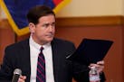 In this Nov. 30, 2020, file photo, Arizona Gov. Doug Ducey handed over his signed election documents to certify the election results for federal, stat