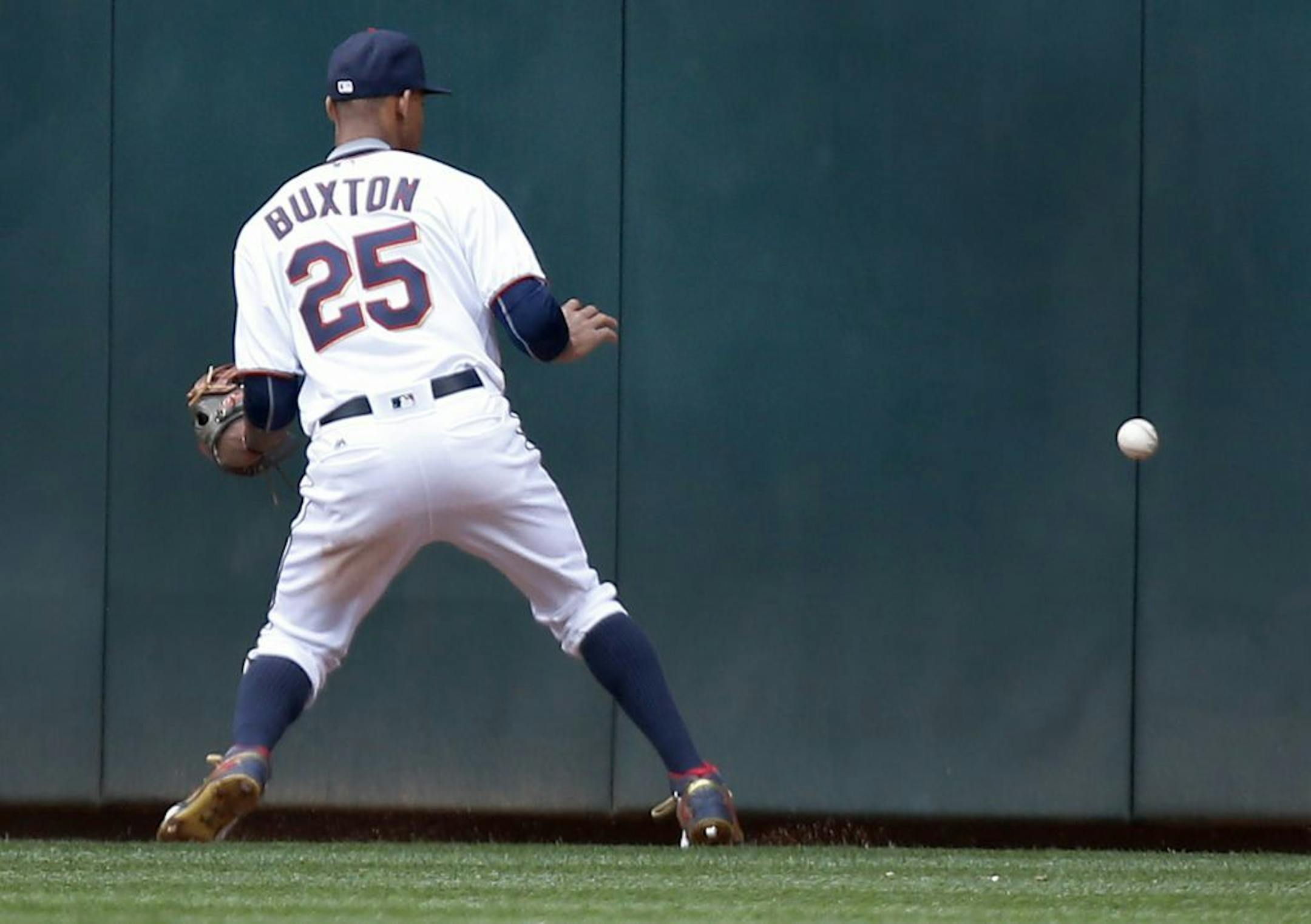 Byron Buxton (25) attempted to field a ball hit of the wall by Yadiel Rivera (29) in the ninth inning. Rivera had a double and ended up at third base when Buxton dropped the ball twice for an error while trying to pick it up.