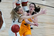 Iowa's Caitlin Clark, right, passes the ball around UConn's Paige Bueckers back when the two squared off in the 2021 Sweet 16 in San Antonio, the only